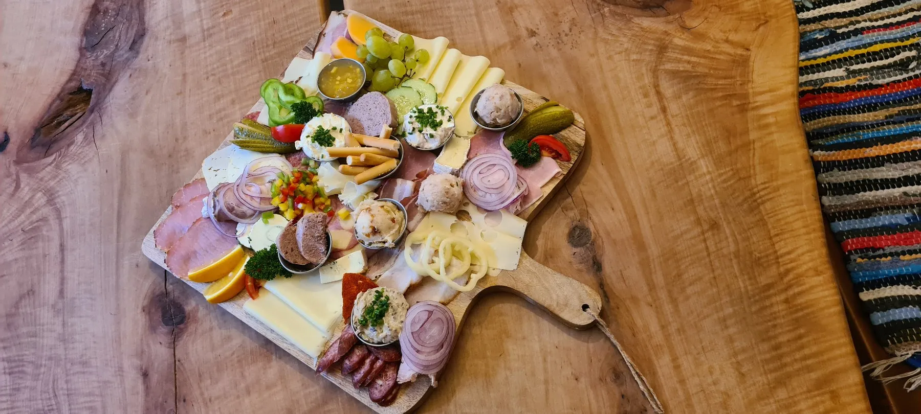 Reich belegte Brettljause auf einem Holzbrett